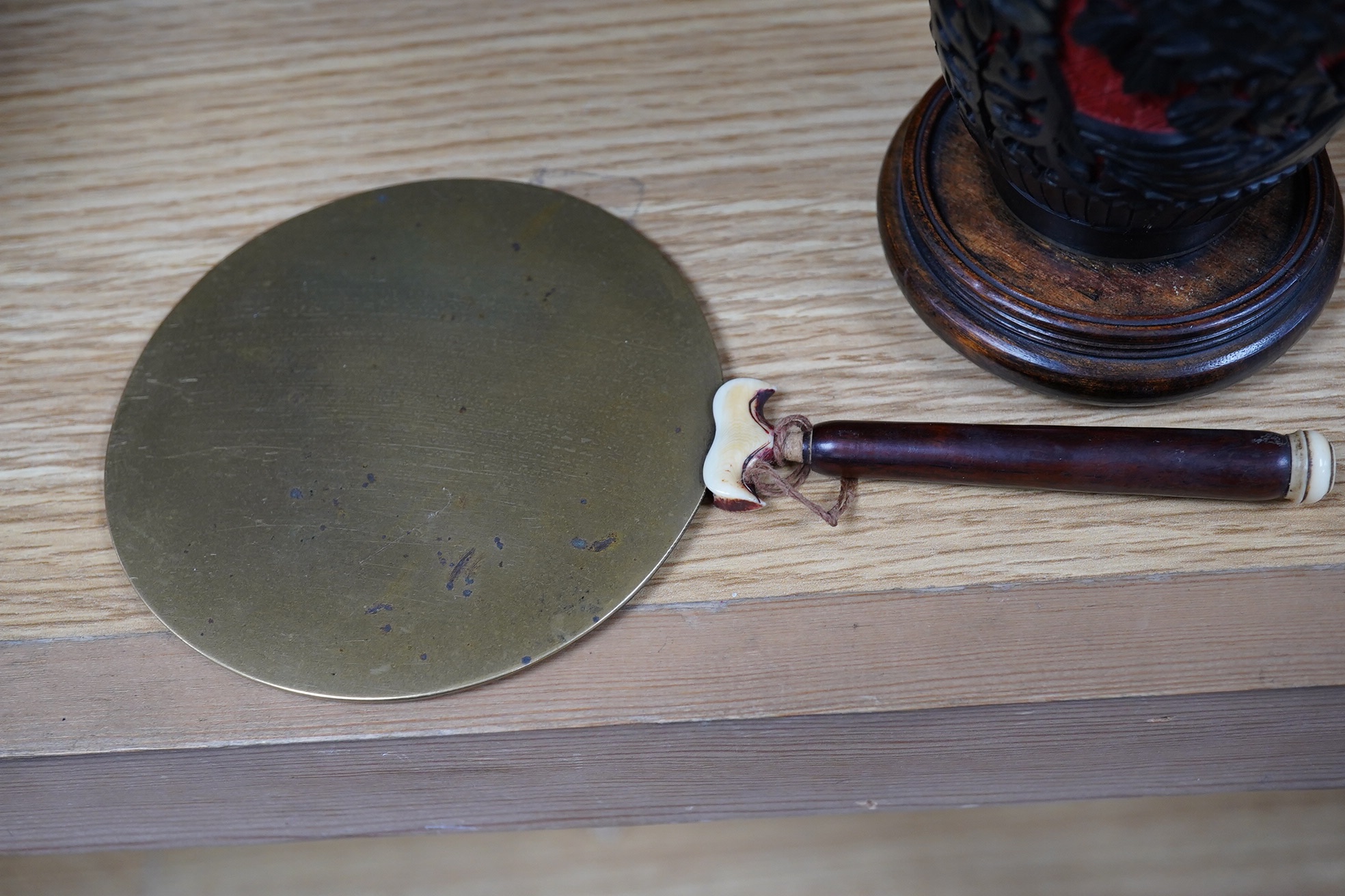 A Chinese bronze bowl, 17cm diameter, a lacquer vase, 15cm high, and a Chinese hand mirror with ivory inlay (3). CITES Submission reference 1UK5HNLM. Condition - fair to good